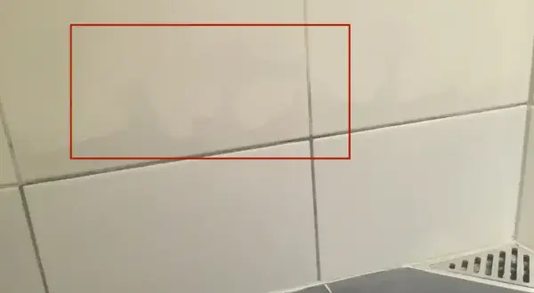 Fuktskada badrum tecken syns som mörka fläckar på kaklet. Vatten har trängt in.