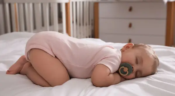 Dlaczego dziecko śpi z pupą do góry? Odkryj naturalne powody