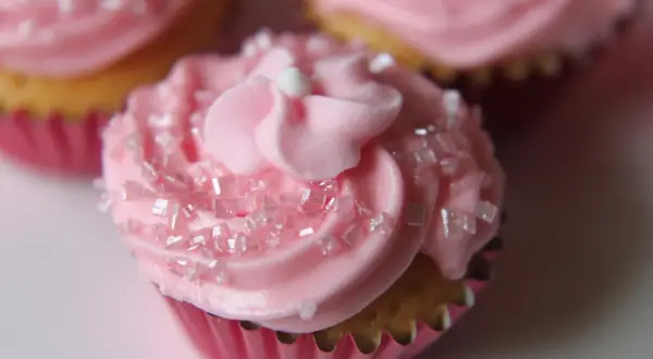 Rosa muffins med sockerströssel och fluffig frosting. Perfekt för en festlig stund.