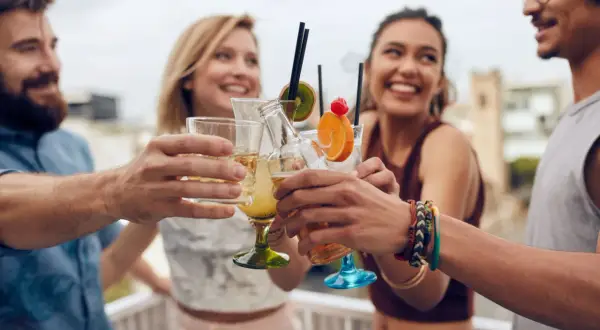 Amici brindano con cocktail colorati, pensando ai birra valori nutrizionali.