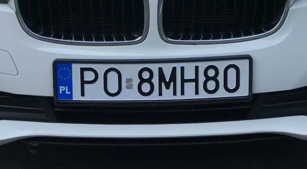 Białe auto z polską tablicą rejestracyjną PO 8MH80.