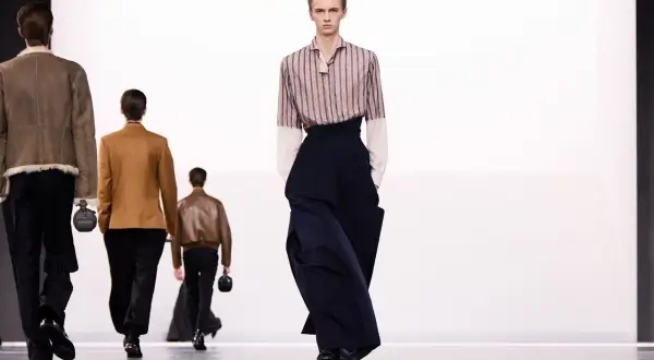 Sfilata di moda maschile: un modello indossa pantaloni ampi blu scuro. Taglia 16 a cosa corrisponde?