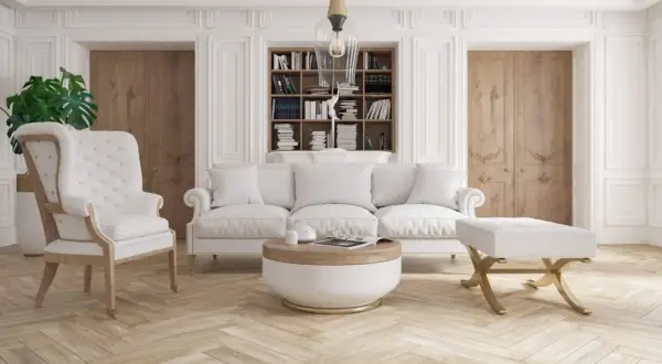 Elegancki salon z białymi meblami i sztukaterią. Aranżacje z klasycznym fotelem, sofą i stolikiem kawowym.