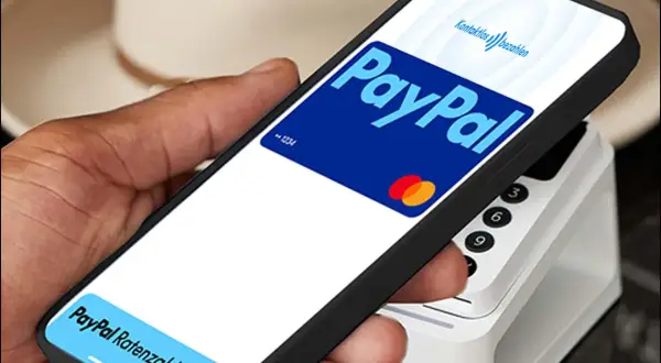 Hand hält Smartphone mit PayPal-Logo und "Kontaktlos bezahlen" für eine schnelle Transaktion. Unten: "PayPal Ratenzahlung".