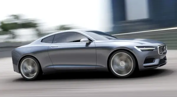 Eleganckie, szare volvo coupe pędzi po drodze, rozmywając tło.