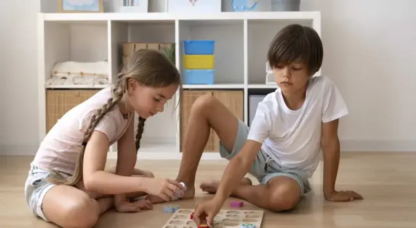 Niños concentrados en un rompecabezas de números, una de las muchas actividades para niños de 6 a 12 años.