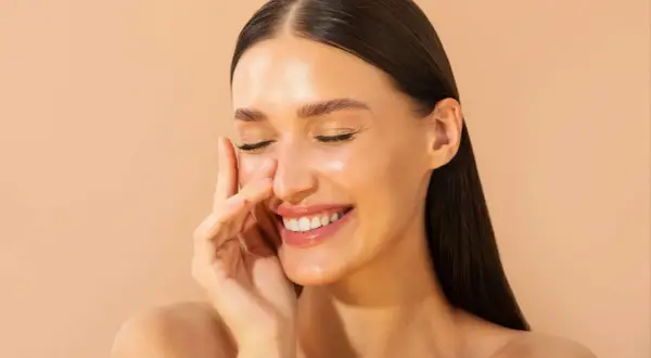 Une femme rayonnante sourit, découvrant les bienfaits du cuivre sur les cheveux. Sa peau lumineuse et ses cheveux brillants témoignent de sa beauté naturelle.