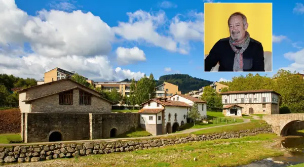 Paisaje vasco con casas tradicionales y modernas, y un retrato de Karlos Arguiñano, mostrando de donde es Arguiñano.