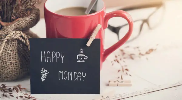 Czerwony kubek kawy, bukiet suszonych traw i tabliczka z napisem "Happy Monday" zapowiadają nowy tydzień.