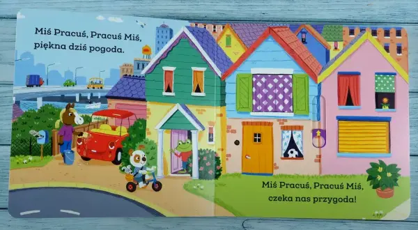 Miś Pracuś, Pracuś Miś, wesoło jedzie na rowerku. Przed kolorowymi domkami czeka go przygoda!