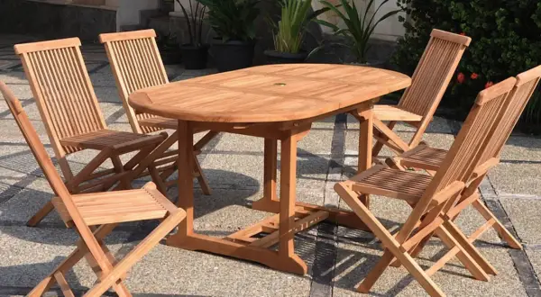 Ensemble de jardin en teck matière, table ovale et chaises pliantes, parfait pour profiter du soleil.