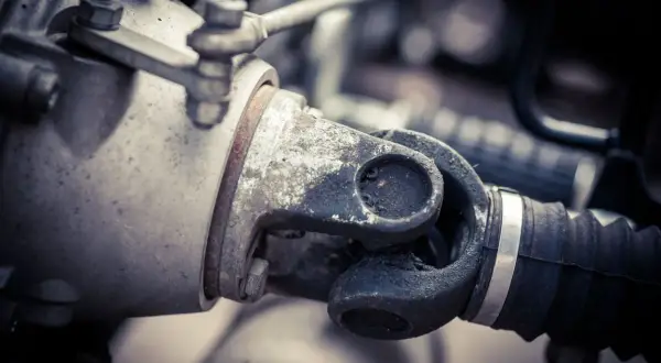 Primer plano del cardan de una moto, mostrando su junta universal y el eje de transmisión, esencial para la potencia.