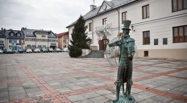 Pomnik chrząszcza w Szczebrzeszynie, jedna z głównych atrakcji miasta, na tle ratusza i placu.