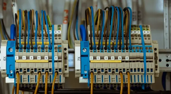 Zasilanie placu budowy z przyłącza docelowego. Widać tu szczegół instalacji elektrycznej z wieloma przewodami w różnych kolorach podłączonymi do listew zaciskowych.