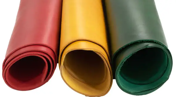 Trois rouleaux de cuir végétal aux couleurs vives : rouge, jaune et vert. Parfait pour vos créations artisanales.