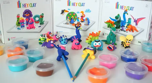 Kolorowe stworki i dinozaury z masy plastycznej Hey Clay, gotowe do zabawy.