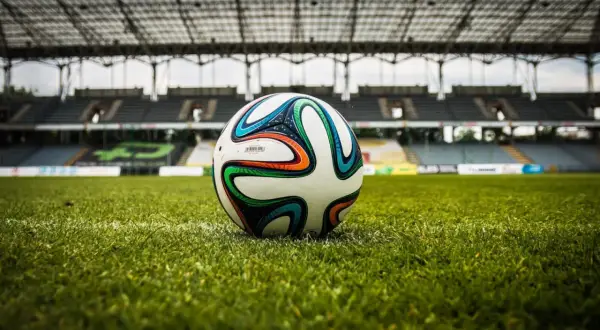 Piłka na murawie stadionu, gotowa do gry. Czekamy na sygnał, by dowiedzieć się, ile trwa dogrywka w piłce nożnej.