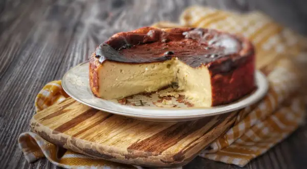 Una golosa cheesecake basca, con la sua crosta caramellata e l'interno cremoso, pronta per essere gustata.