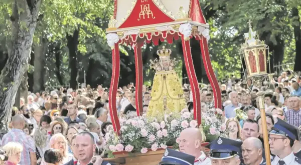 Procesja z figurą Matki Boskiej w miejscowości Święta Anna. Tłumy wiernych towarzyszą uroczystości.