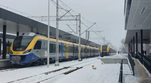 Pociągi PKP na trasie Kraków-Oświęcim przez Skawinę stoją na zaśnieżonej stacji.