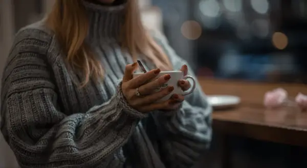 Ciepły, gruby sweter z golfem otula ramiona. Dłonie z rudym lakierem trzymają kubek z kawą. Jak sprawić, by wełna nie gryzła?