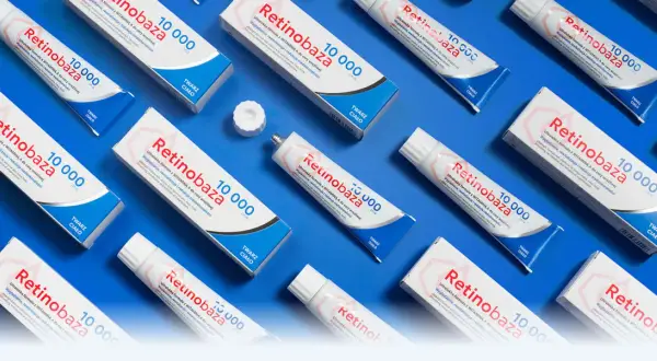 Wiele tubek kremu Retinobaza z witaminą A (retinyl palmitate) na niebieskim tle. Krem wygładza i redukuje niedoskonałości.