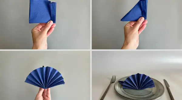 Steg-för-steg-guide för servettvikning stående. En blå servett viks till en solfjäderform och placeras på en tallrik med bestick.