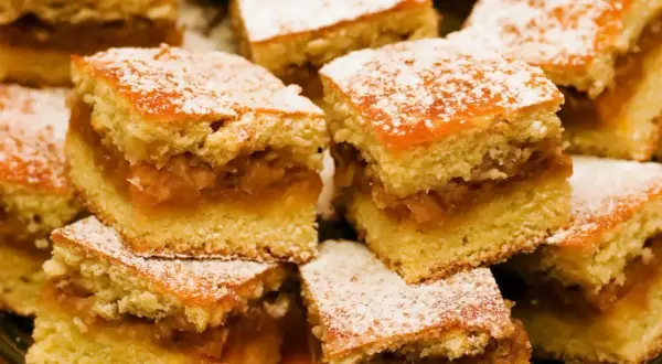 Pyszne ciasto z jabłkami, pokrojone w kostkę i posypane cukrem pudrem. Idealne na deser!