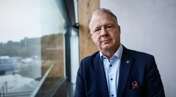 VD Volvo, en man i mörk kostym med Volvo-märke på kavajslaget, tittar mot kameran.