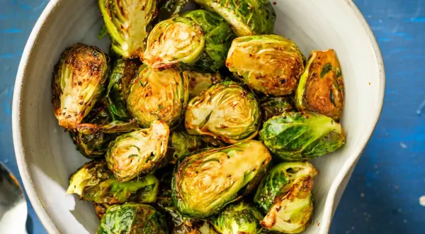 Krispiga och gyllene brysselkål i airfryer, serverade i en skål. Perfekt tillbehör!