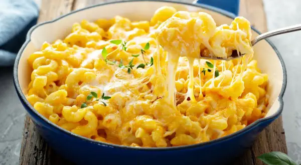 Pyszne, ciągnące się mac n cheese w niebieskiej patelni, z gałązkami tymianku. Idealne na pocieszenie.