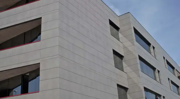 Edificio moderno con fachada de gres porcelánico para fachadas exteriores, líneas horizontales y ventanas oscuras.