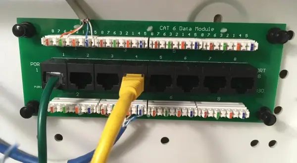 Panel sieciowy Cat 6 z portami RJ45. Widoczne okablowanie i złącza, standard okablowania RJ45 a czy b jest kluczowy dla poprawnego działania sieci.