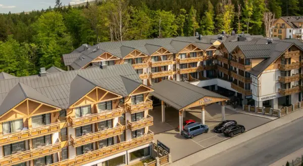 Nowoczesny hotel Platinum Mountain & Spa w otoczeniu lasu. Elegancka architektura z drewnianymi elementami i licznymi balkonami.