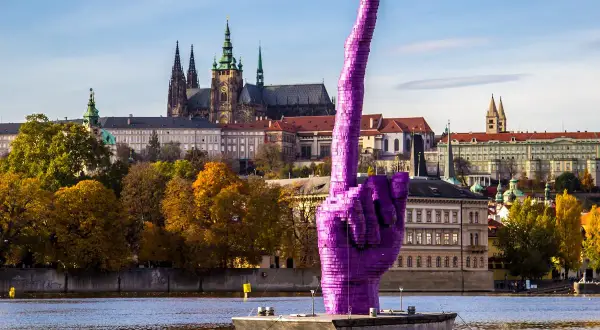 Fioletowa dłoń na Wełtawie, symbol Pragi, miasta, z którego słyną Czechy. W tle katedra św. Wita i jesienne drzewa.