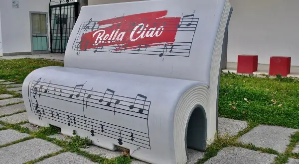 Ławka w kształcie książki z nutami i napisem "Bella Ciao tekst".