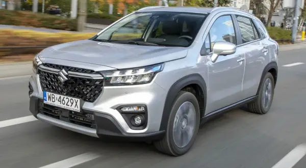 Srebrny Suzuki S-Cross w ruchu miejskim. Wiele osób szuka **suzuki s-cross opinie** przed zakupem.