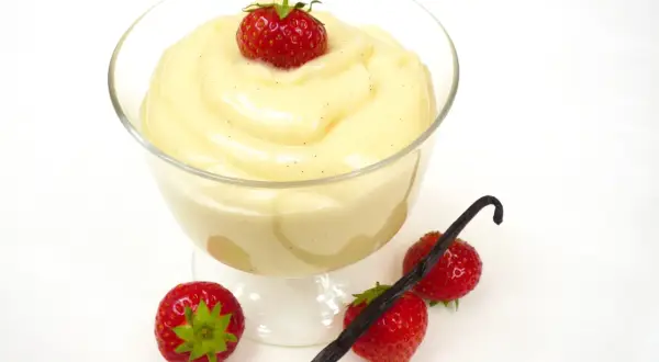 Cremiger Vanillepudding, frisch zubereitet, mit Erdbeeren und Vanilleschote garniert. So einfach ist pudding selber machen!