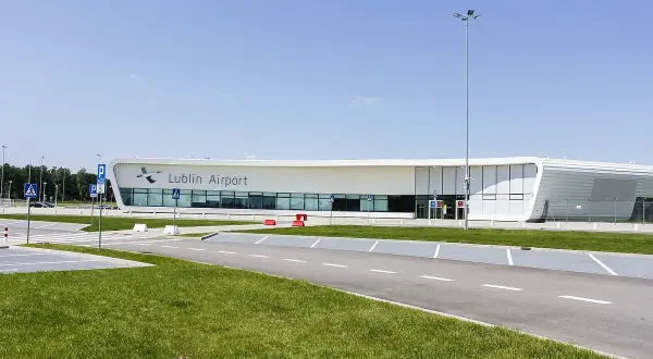 Nowoczesny budynek lotniska Lublin Airport w Świdniku. Widok na parking i drogę prowadzącą do terminala, gdzie oczekiwane są przyloty.