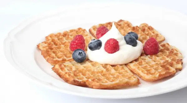 Små, gyllene våfflor med fluffig grädde och färska bär. Ett perfekt resultat av ett enkelt våffelsmet recept.