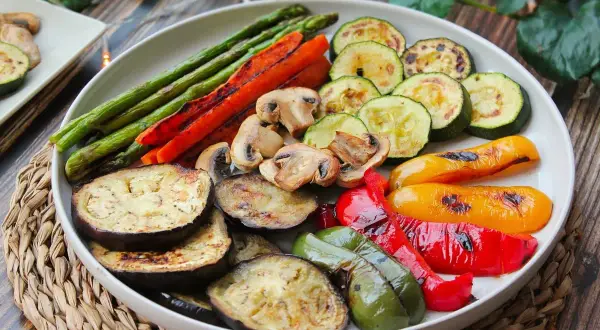 Una colorida parrillada de verduras: espárragos, zanahorias, champiñones, calabacín, berenjena y pimientos asados a la perfección.
