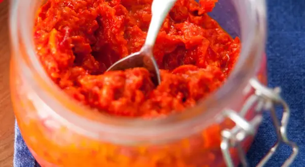 Ein Glas mit selbstgemachtem Ajvar, bereit zum Genießen. Dieses Ajvar Rezept ist ein Muss für jeden Liebhaber von herzhaften Aufstrichen.
