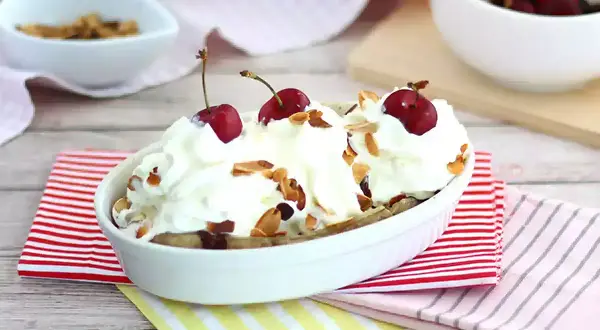 En läcker banana split med vispgrädde, körsbär och mandelflagor. En klassisk dessert som passar alla tillfällen.