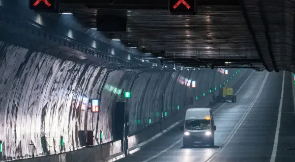 Ein Van fährt durch den beleuchteten **Tunnel Usedom**, während rote X-Zeichen über der Fahrbahn auf eine Sperrung hinweisen.