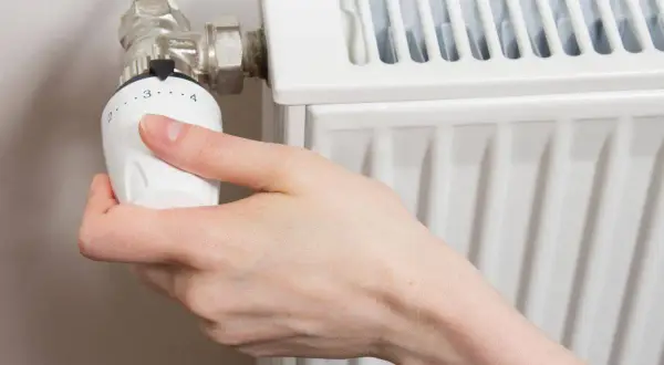 Mano che regola la temperatura dei termosifoni svedesi.