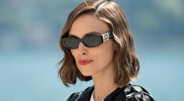 Kobieta w okularach przeciwsłonecznych i stylowej fryzurze french bob, z burzą fal na głowie, wygląda elegancko.