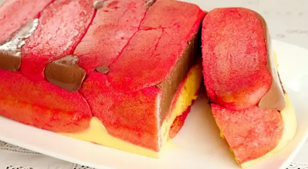 Zuppa inglese ricetta originale emiliana: strati di pan di spagna rosa, crema pasticcera gialla e cioccolato, decorata con savoiardi rossi e gocce di cioccolato.