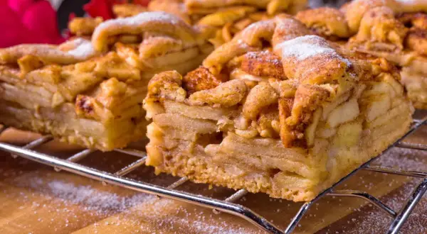 Pyszna szarlotka z jabłkami, idealna do pieczenia na termoobiegu. Posypana cukrem pudrem, czeka na widelce.