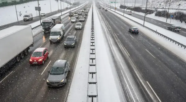 Autostrada A1 w zimowych warunkach, z samochodami i ciężarówkami na ośnieżonej nawierzchni.