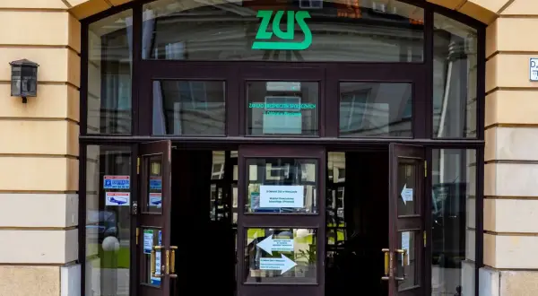 Wejście do ZUS, gdzie można załatwić sprawy związane z subkontem ZUS. Zielone logo ZUS nad drzwiami.